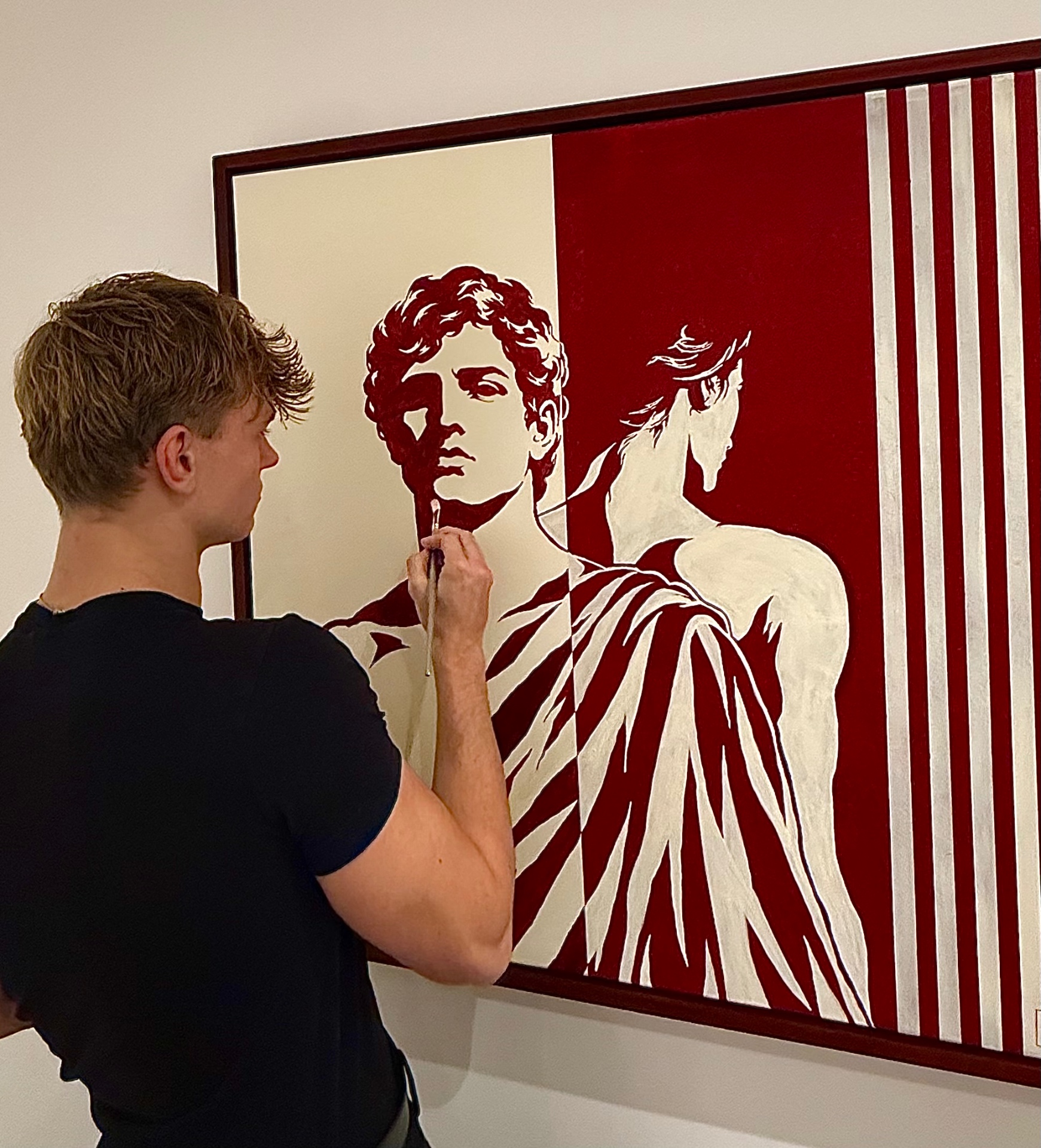 Max Noah bei der Arbeit an einem großen, gerahmten Bild